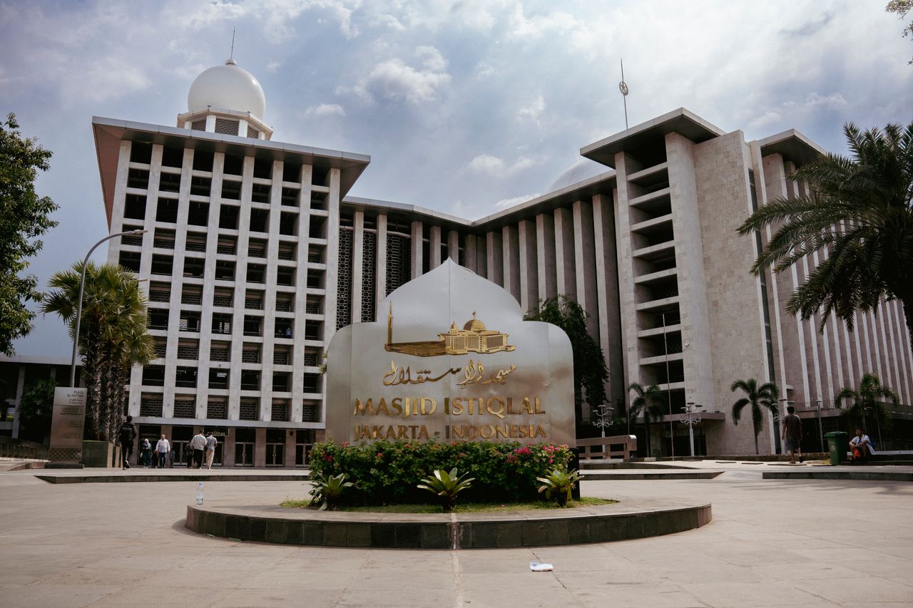 services-01 View of Masjid Istiqlal with its distinctive architecture and cloudy skies in Jakarta, Indonesia.